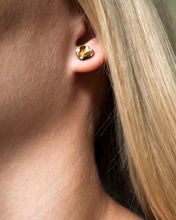 Handmade black porcelain stud earrings with irregular shape and gold luster interior