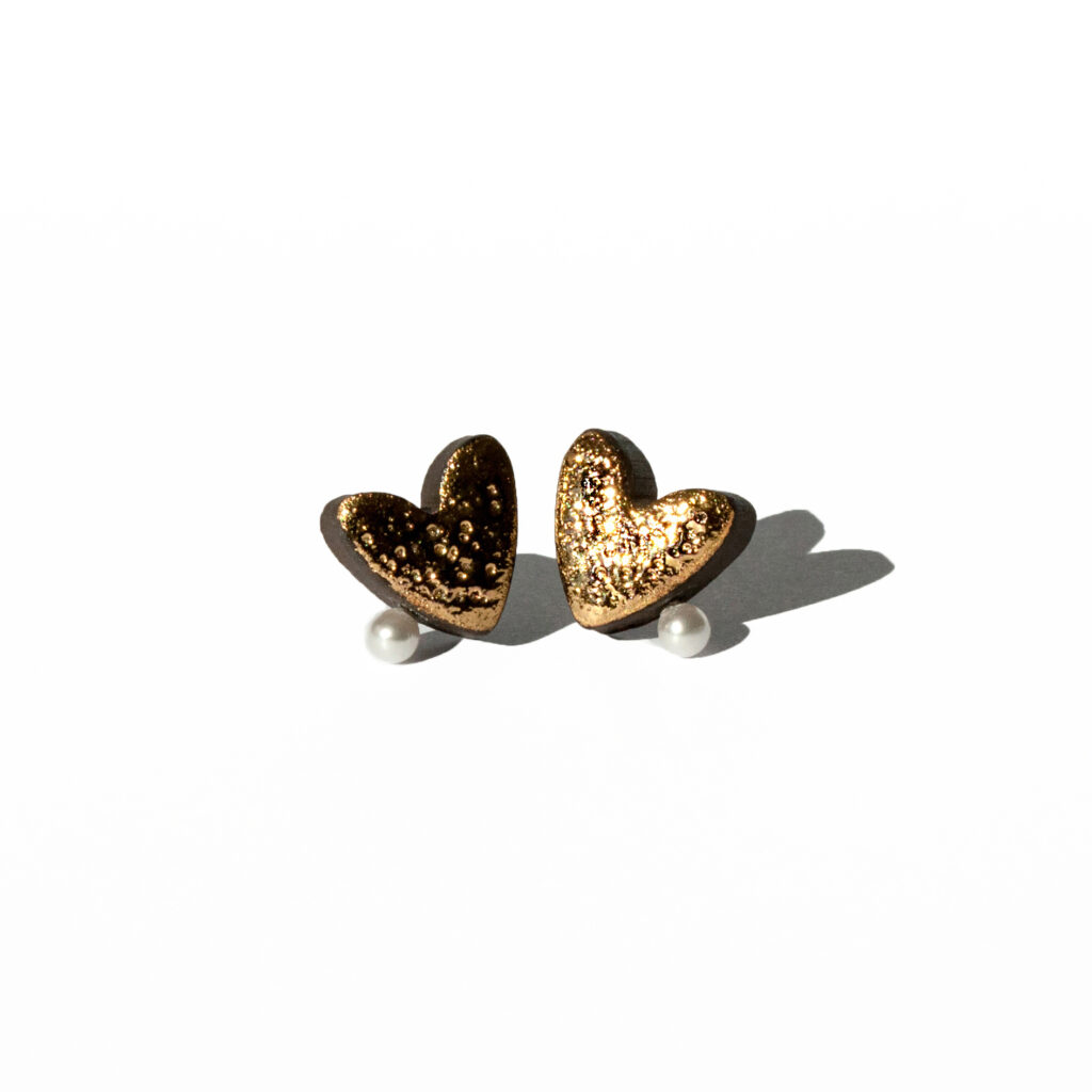Handmade ceramic heart earrings with moon texture, gold luster, and a pearl detail