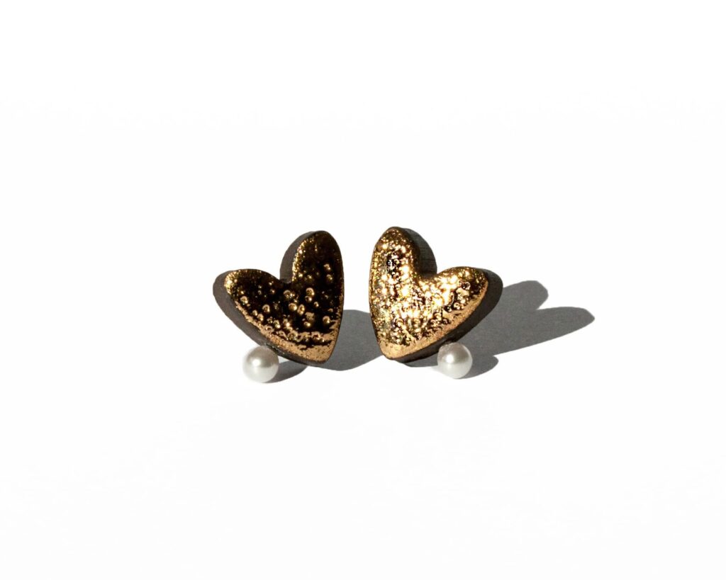 Handmade ceramic heart earrings with moon texture, gold luster, and a pearl detail