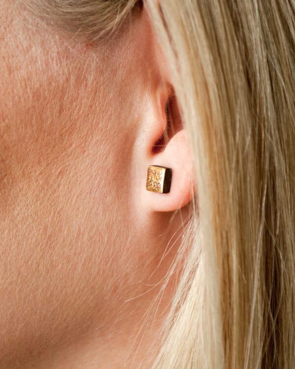 Square handmade ceramic earrings with moon-textured black clay and 24k gold luster accents