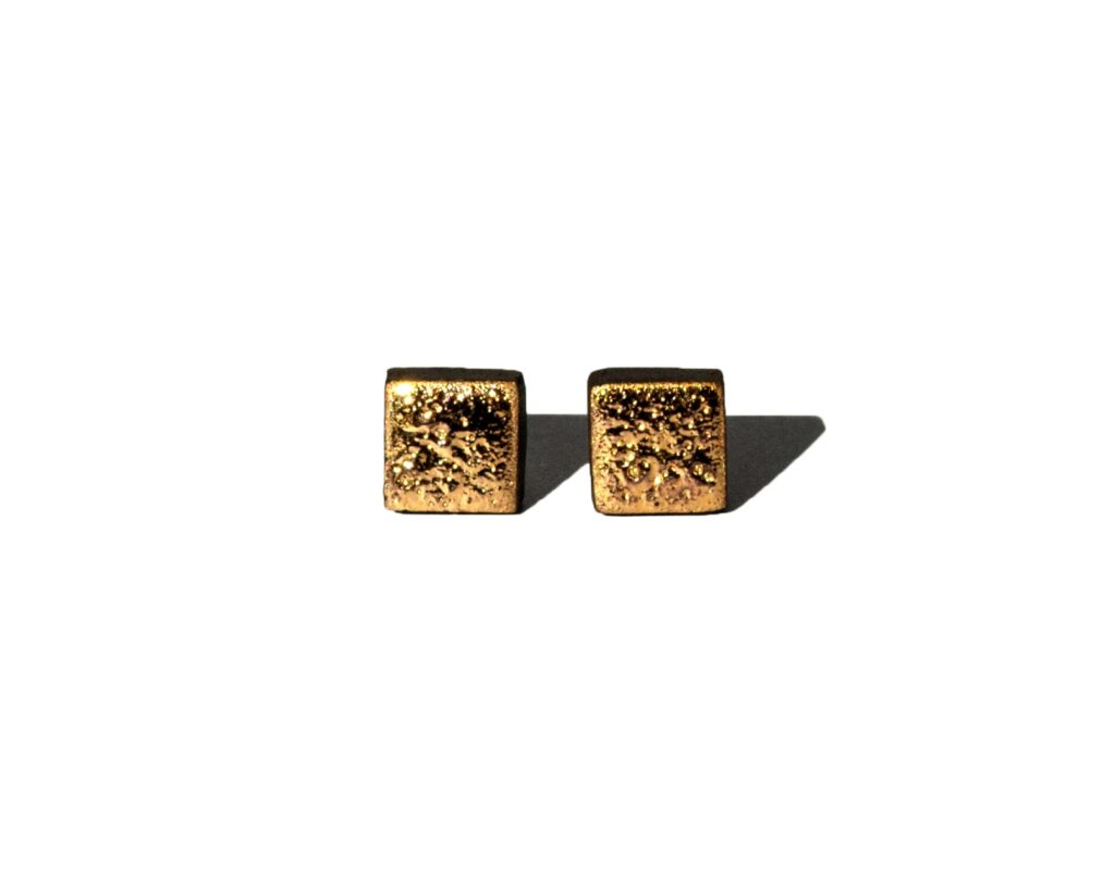Square handmade ceramic earrings with moon-textured black clay and 24k gold luster accents