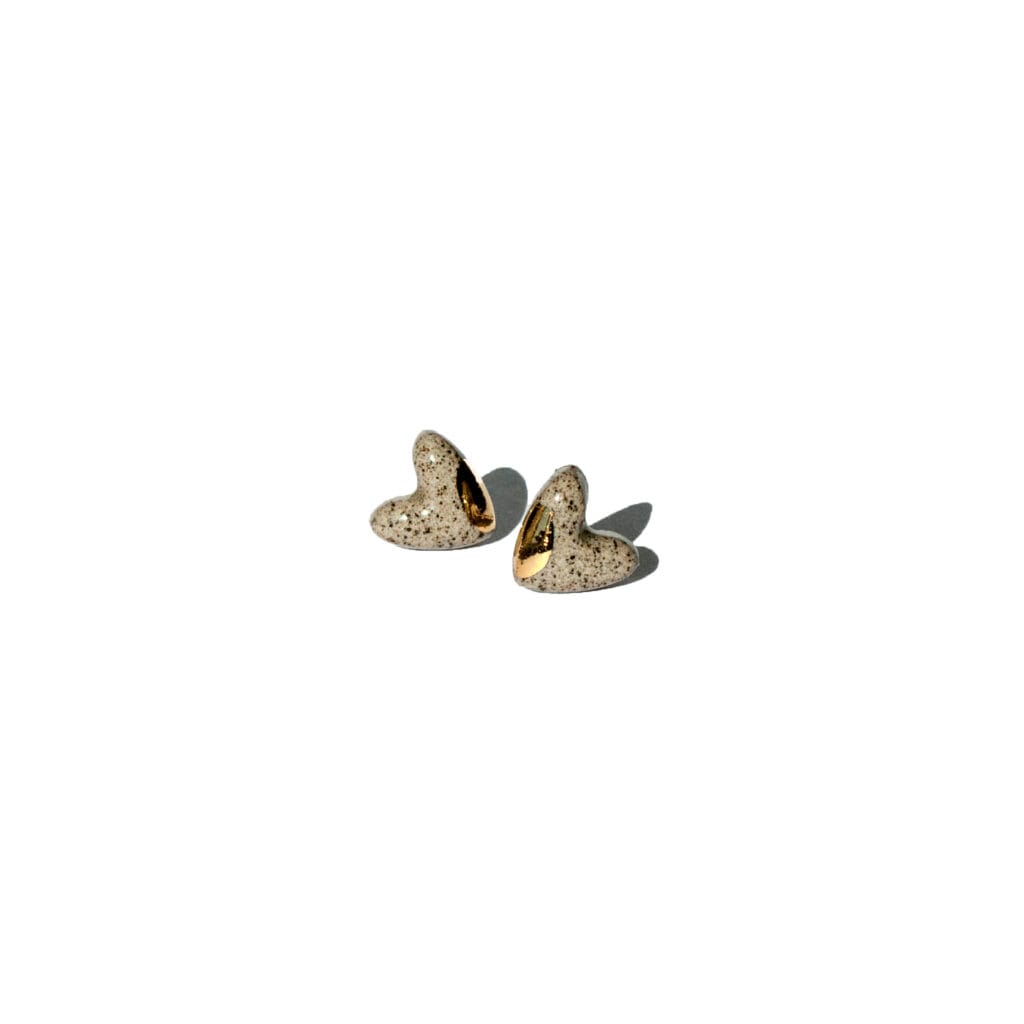Handmade grey stoneware heart-shaped stud earrings with clear glossy glaze and gold luster accents on the sides