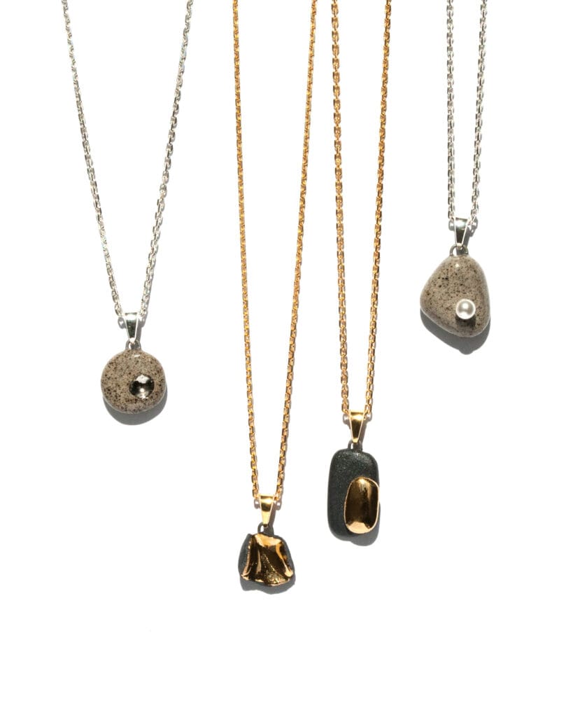 Handmade grey stoneware pendant necklace with black grog, round shape, clear glossy glaze, hand-painted platinum dimple detail, on sterling silver chain and bail