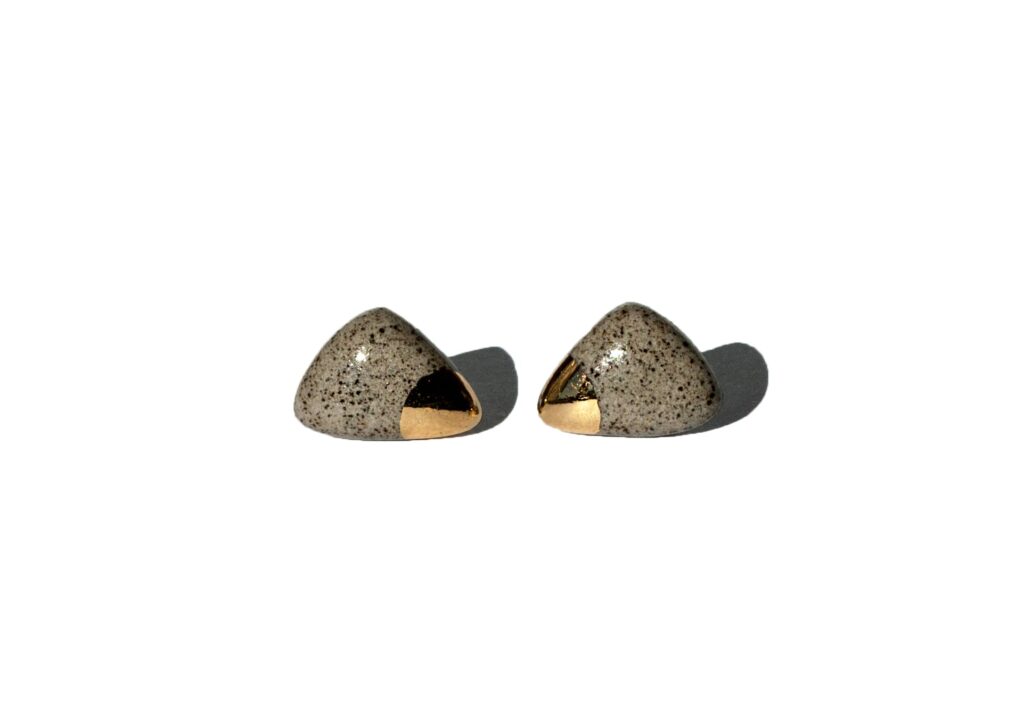 Handmade grey stoneware triangular stud earrings with rounded corners, clear glossy glaze, gold luster accents, and sterling silver posts