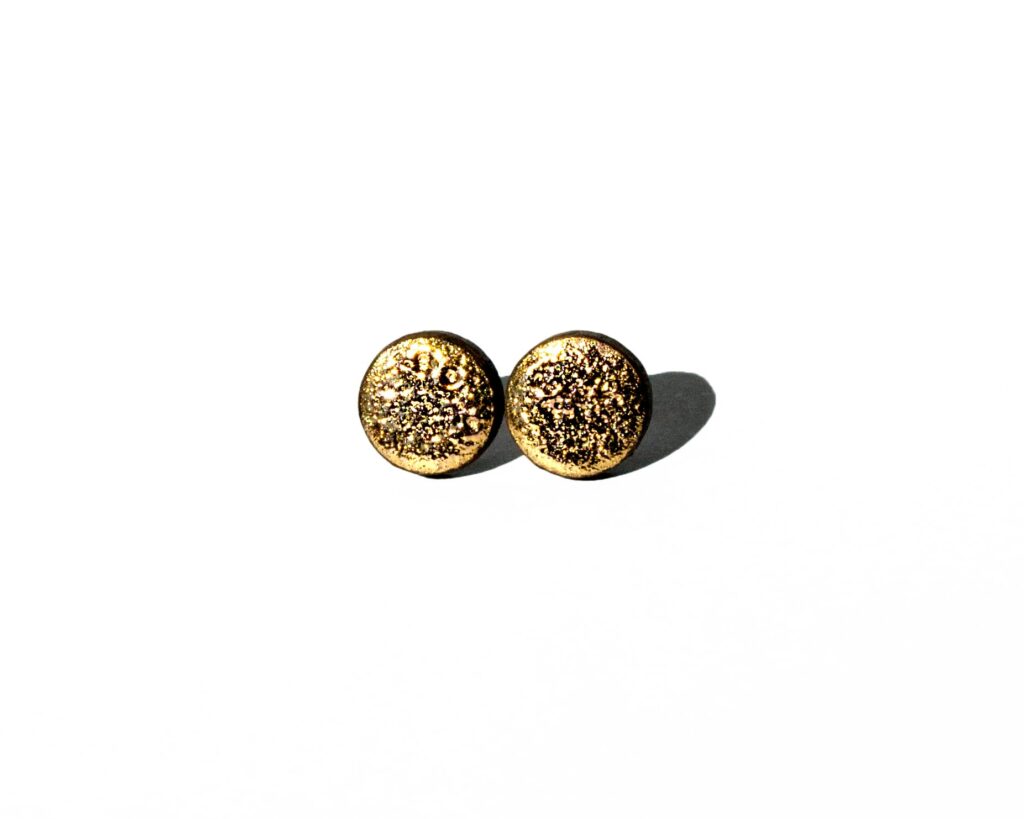 Handmade round ceramic earrings with moon-textured black clay and 24k gold luster accents