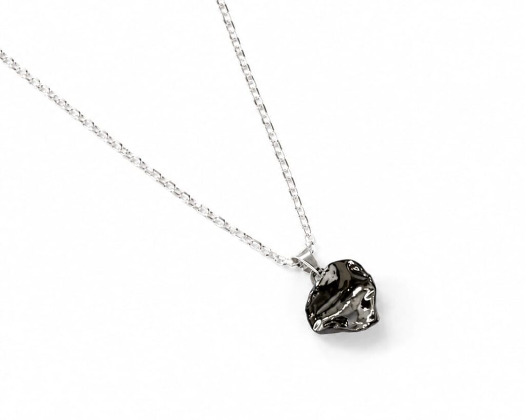 Handmade irregular black porcelain pendant necklace with matte unglazed exterior, glossy inner glaze, and platinum luster, on a sterling silver chain