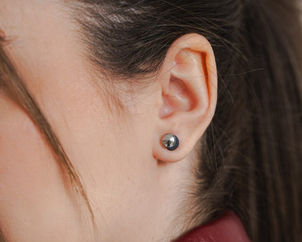 Dual Midi Black Platinum handmade black porcelain stud earrings with platinum luster worn on ear, close-up