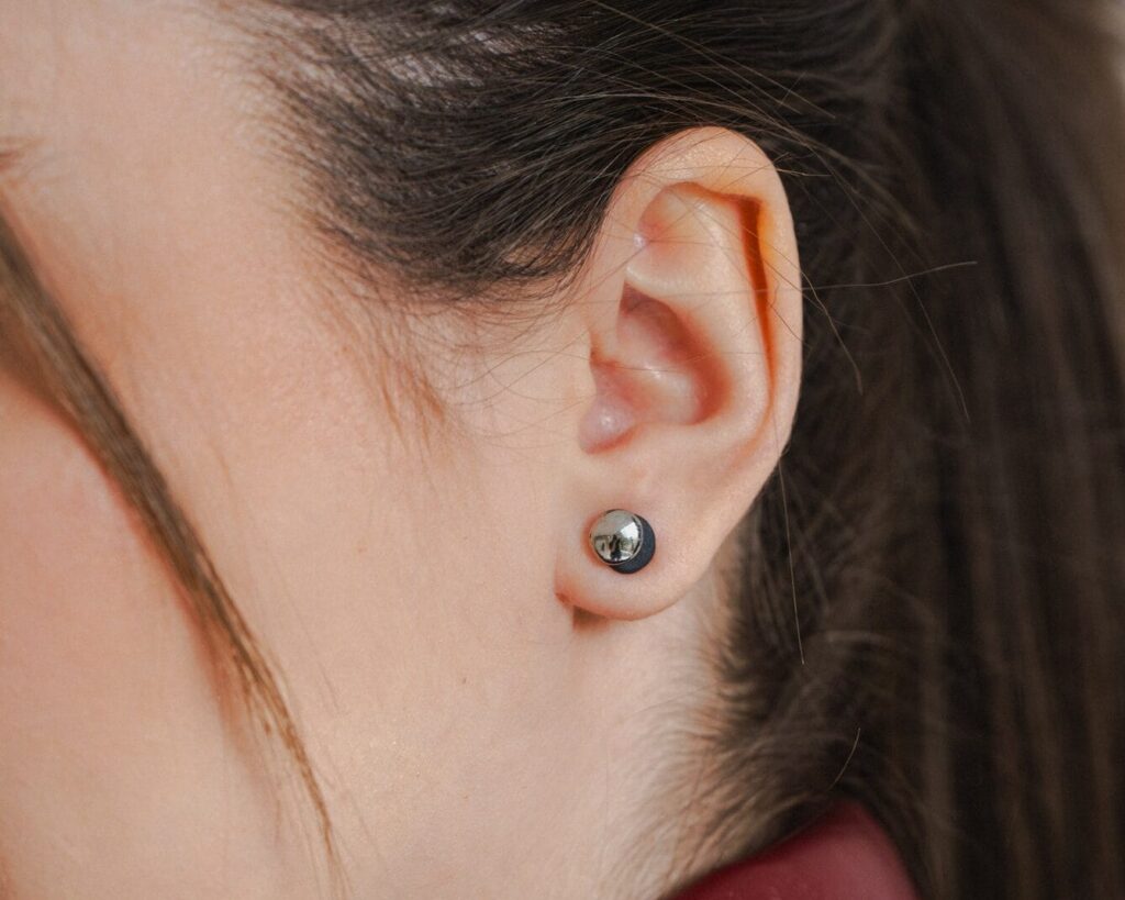 Dual Midi Black Platinum handmade black porcelain stud earrings with platinum luster worn on ear, close-up