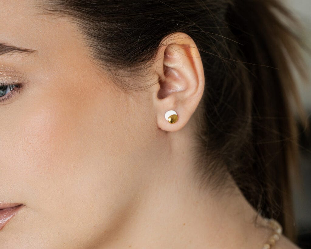 Dual Midi White handmade white porcelain stud earrings with gold luster worn on ear