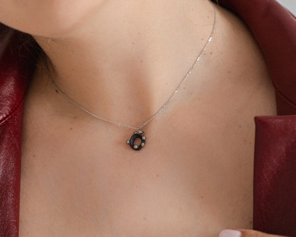 Black Awakening Platinum handmade black porcelain necklace with platinum luster worn by a model, close-up view